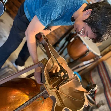 打楽器のチューニングボルトを調整する作業